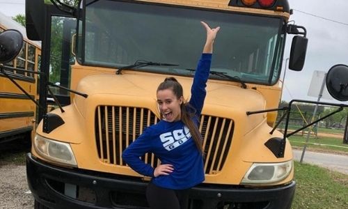 Girl in front of a school bus
